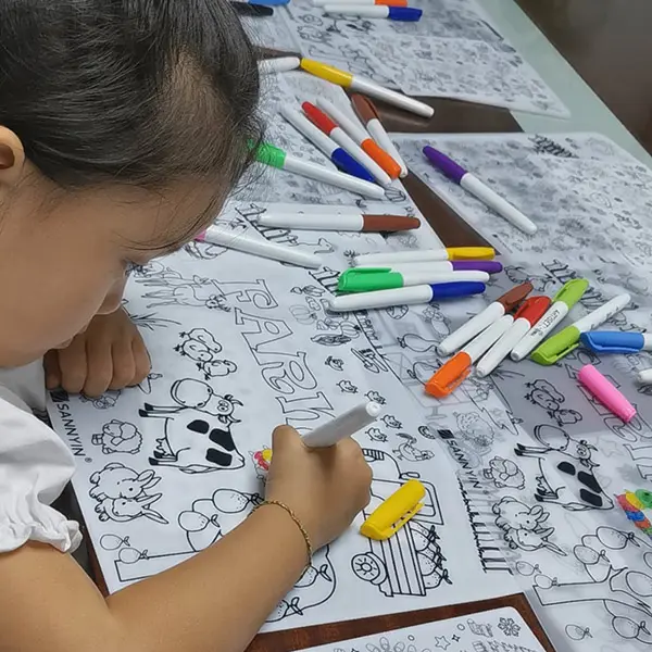kid drawing on colouring mat